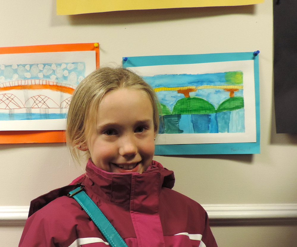 Sophia Wells stands beside her watercolor painting of the Maine Kennebec Bridge.