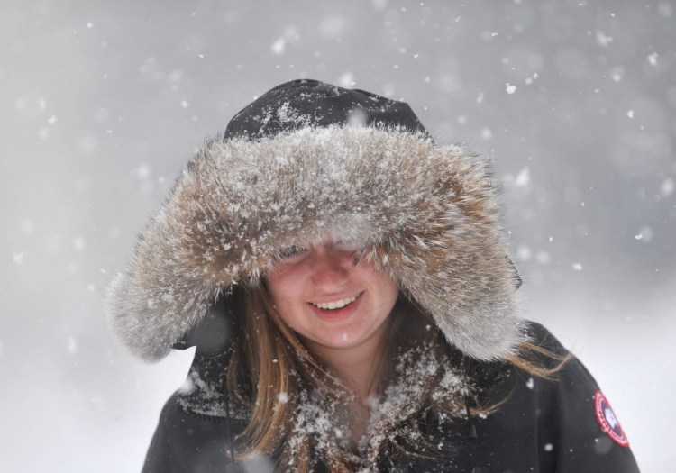 Julia Holzman walks through falling snow Saturday on Mayflower Hill Drive in Waterville as a brief storm blankets the area.