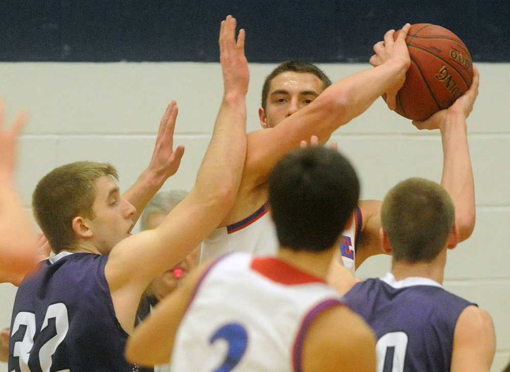 Messalonskee High School’s Nick Mayo (24) looks to pass the ball as he is defended by Hampden Academy’s Conary Moore, left and Jake Black, right, in the first half Wednesday in Oakland.