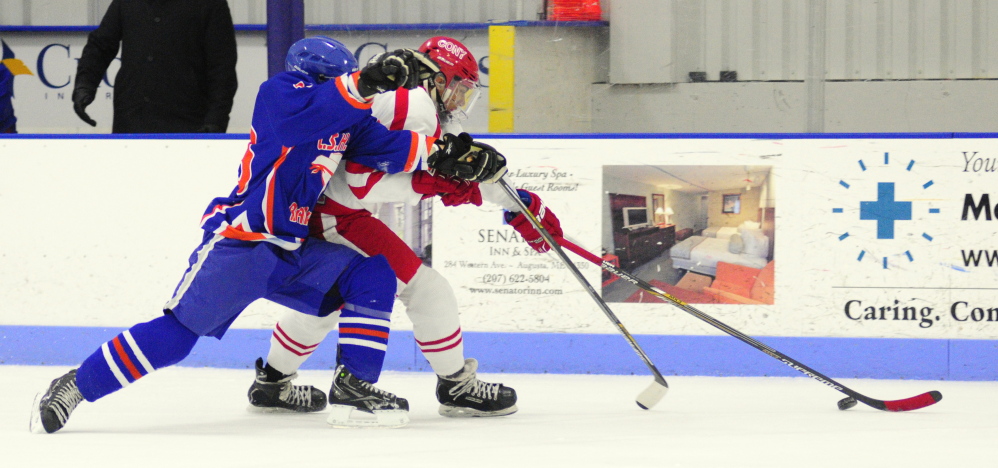 Lawrence/Skowhegan forward Alex Paul, left, and Cony’s Cameron Wilson battle for a puck during an Eastern A game Thursday at the Bank of Maine Ice Vault in Hallowell.