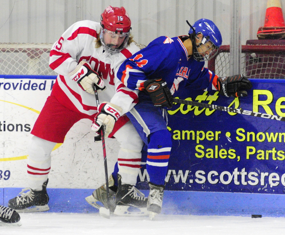 Cony’s Dakota Benson, left, and Lawrence/Skowhegan’s Alex Paul battle for a puck during an Eastern A game Thursday at the Bank of Maine Ice Vault in Hallowell.