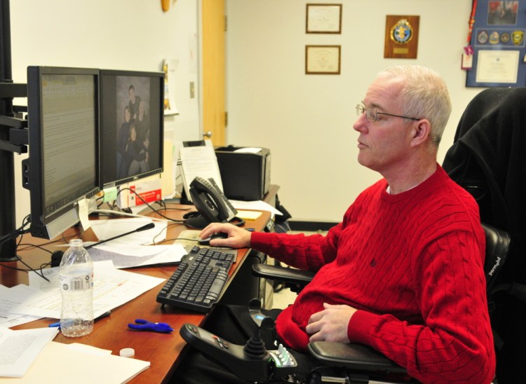 Augusta Police Chief Robert Gregoire works in his office Friday at police headquarters in Augusta. He has gained enough strength and dexterity in his hands recently to be able to use a computer mouse again.