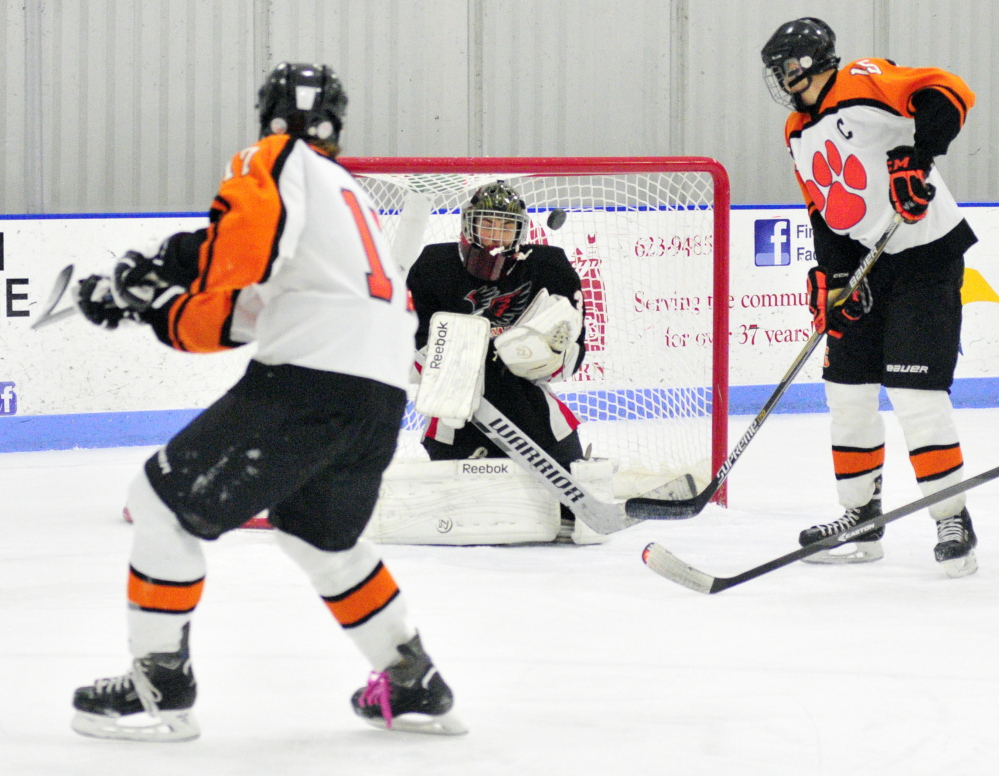 Gardiner’s Reid Cotnoir, left, takes a shot that starts the play ending with a goal by teammate Logan Peacock, 15, right, to put Tigers up 1-0 in first period during a game against Maranacook/Winthrop on Saturday at the Bank of Maine Ice Vault in Hallowell.