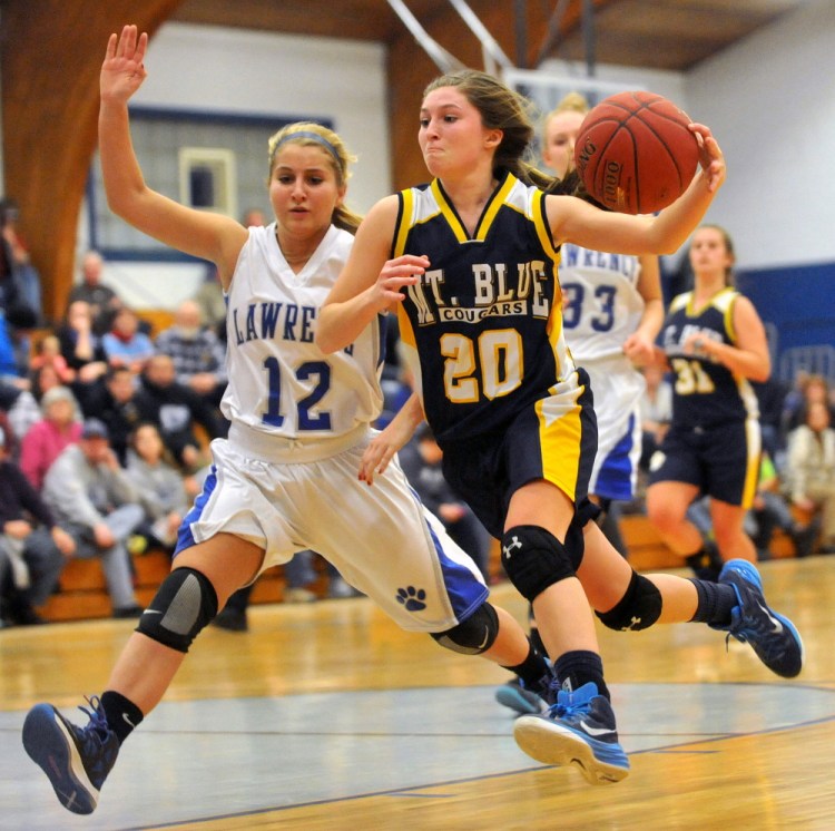 Mt. Blue High School’s Eryn Doiron, right, drives to the basket as Lawrence High School’s Dominique Lewis defends Saturday at Lawrence High School in Oakland.