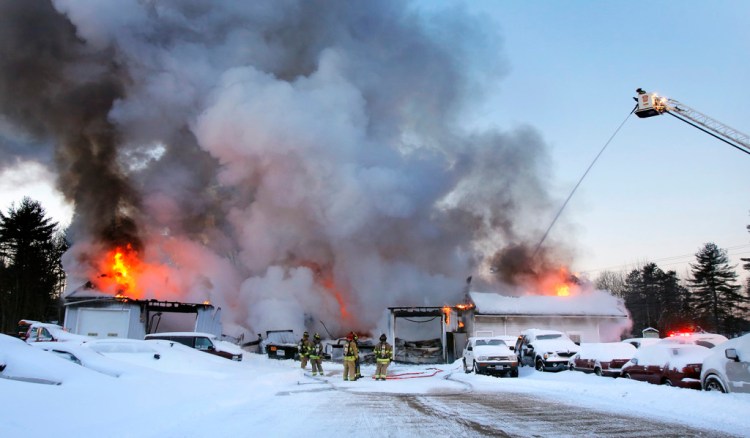 Firefighters battle a fire at 92 York Street in Kennebunk in a building that housed an auto repair shop and a kitchen store. Gregory Rec/Staff Photographer