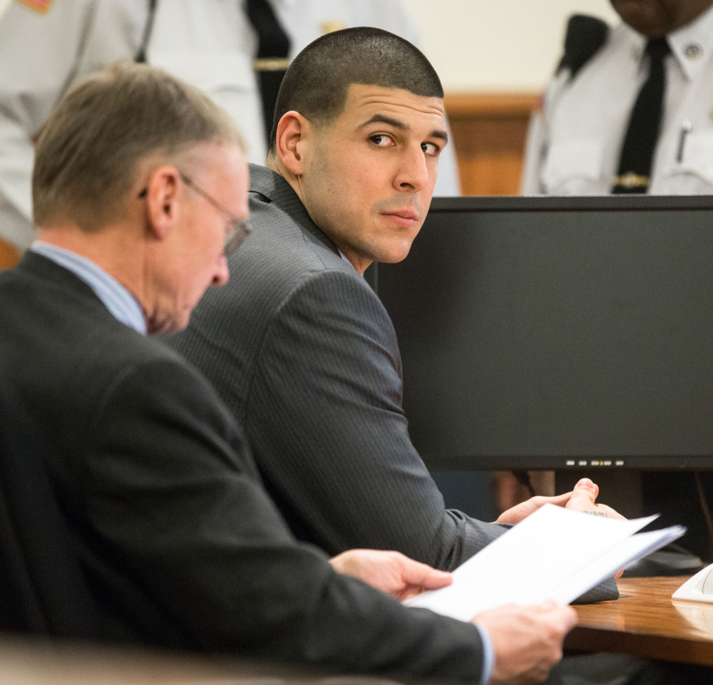 Former New England Patriots player Aaron Hernandez, right, glances towards the Lloyd family during his trial at Bristol County Superior Court in Fall River, Ma.