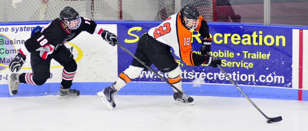 HALLOWELL, ME - JAN. 31: Maranacook/WInthrop's Matt Ingram, left, and Gardiner's Jake Folsom chase after a puck in the corner during a game on Saturday January 31, 2015 at the Bank of Maine Ice Vault in Hallowell. (Photo by Joe Phelan/Staff Photographer)