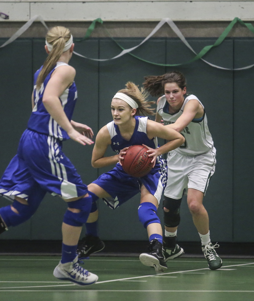 Madison High School guard Kayla Bess grabs a rebound from a Waynflete attempted basket, while Waynflete forward Julianna Harwood attempts to regain possession Tuesday during the Western Class C perliminary game in Portland. Bess scored 17 points to lead the Bulldogs to a 48-41 win.