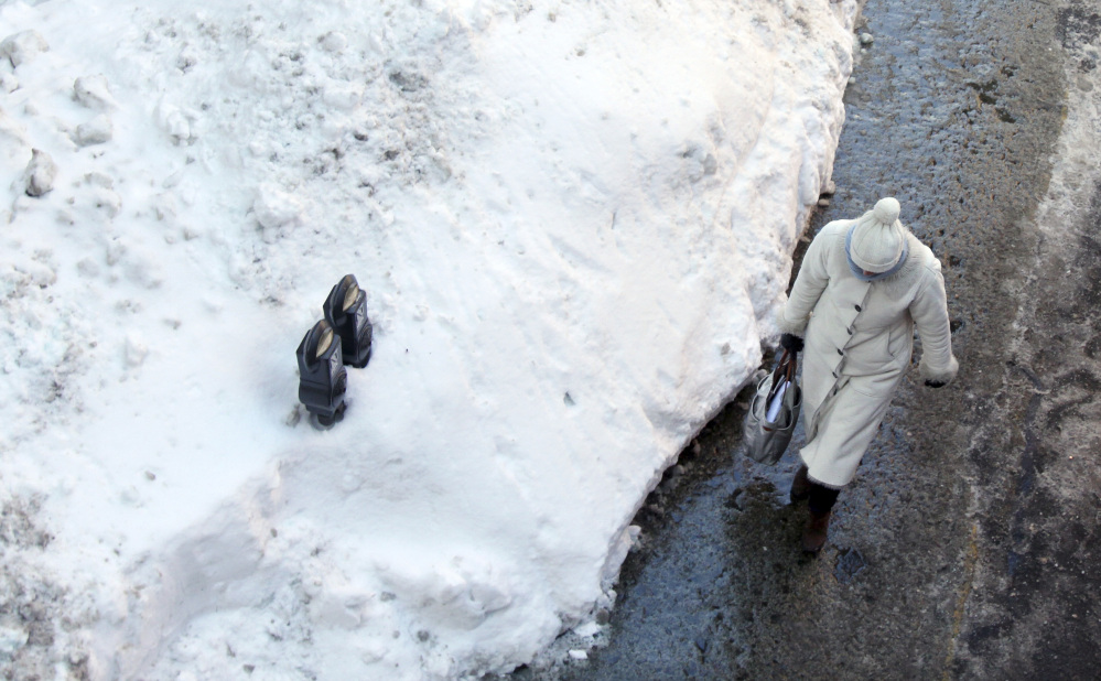 Parking meters are mostly buried in a mound of snow Friday along a street in downtown Boston. Another winter storm that could bring an additional foot or more of snow to some areas is forecast for the region beginning Saturday evening.