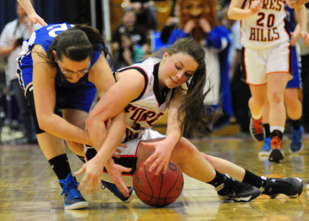 Searsport junior forward Kaitlyn Shute, left, and Forest Hills senior guard Haley Cuddy wrestle for a loose ball during a Western D tournament quarterfinal Tuesday  at the Augusta Civic Center.