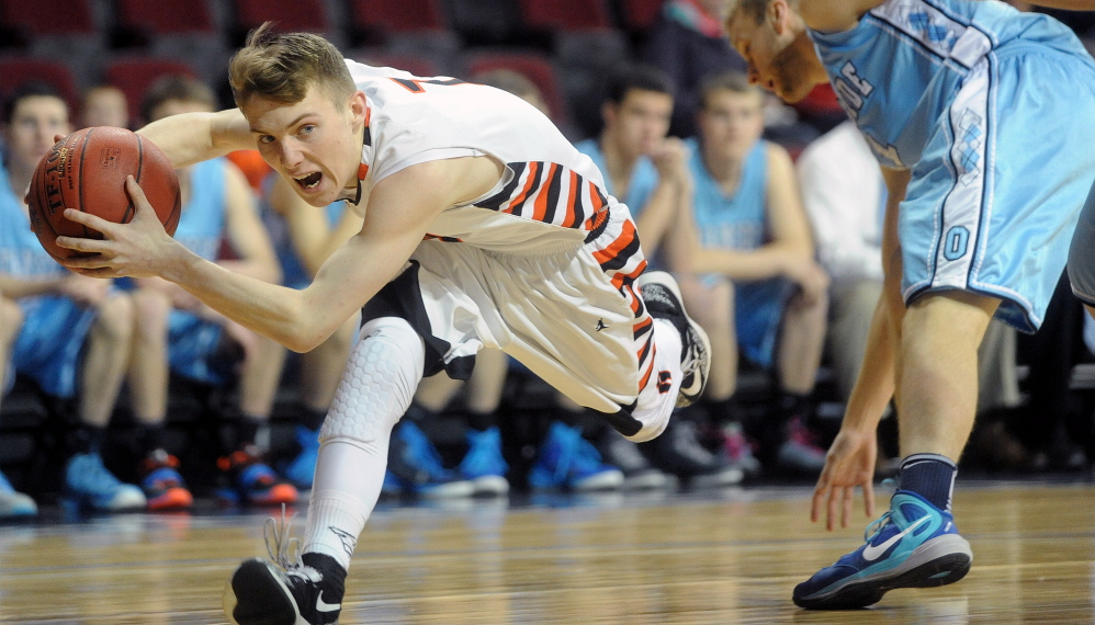 Winslow High School’s Colby Robertson, left, gets fouled by Oceanside High School’s Walker Ranney.