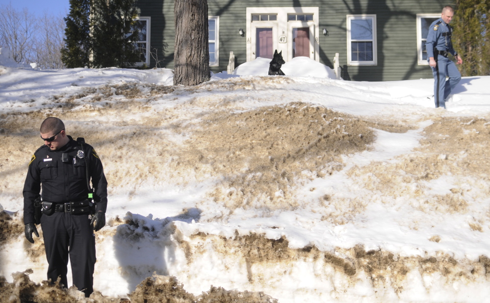 Gardiner Police Officer Normand Gove, left, and State Police canine officer G.J. Neagle search for tracks of a suspect who robbed the Rite Aid pharmacy in Gardiner Wednesday afternoon.