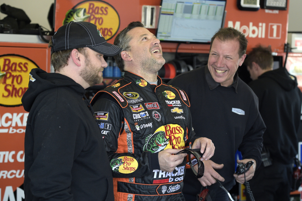 Driver Tony Stewart, center, has a laugh with his crew in the garage during a practice session last week for the Daytona 500 at Daytona International Speedway.