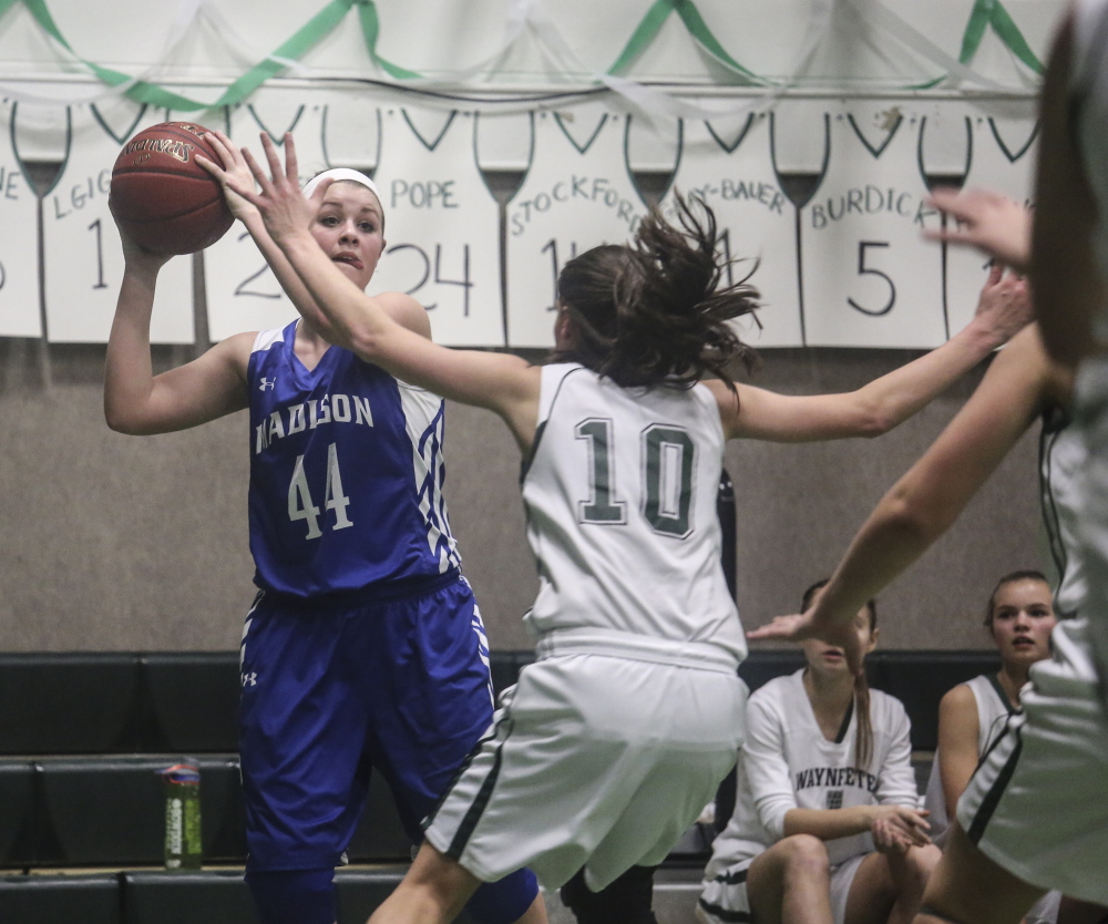 Madison forward Erin Whalen looks for an open teammate while Waynflete forward Julianna Harwood defends during a Western C prelim game Feb. 10 in Portland. The Bulldogs are one win away from reaching the regional finals.