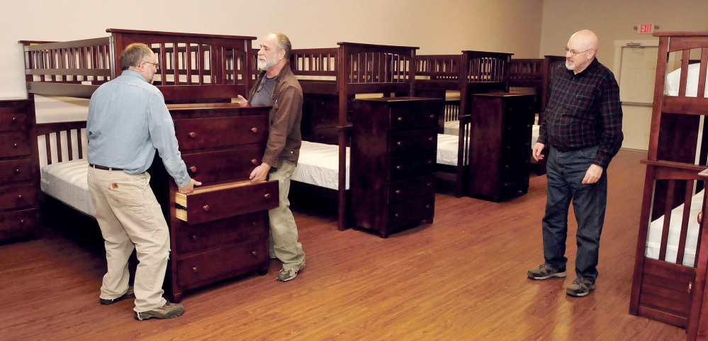 Volunteers help prepare the expanded New Hope Women’s Shelter in Solon on Wednesday. Setting dressers in a dormitory are, from left, Clay Beaulieu, Rob Philpot and pastor Tim Hunt.