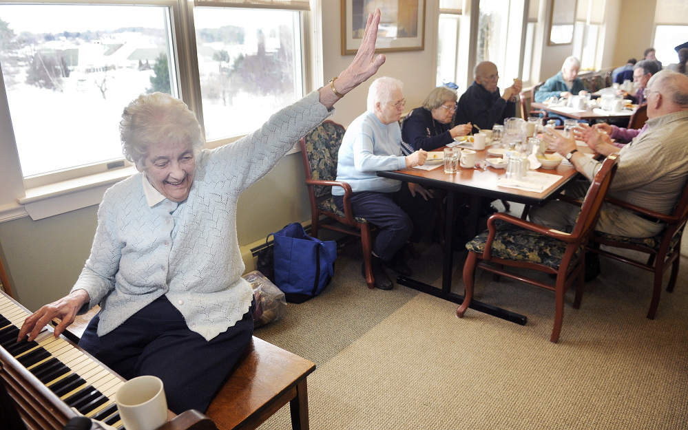 Joyce Fessenden, 83, greets a well-wisher recently while playing the piano during lunch at the William S. Cohen Community Center in Hallowell.