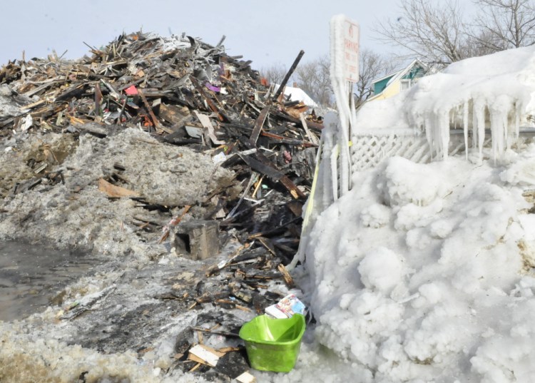 CAP.cutline_standalone:An apartment building on Paris Street in Waterville, shown Tuesday, has been reduced to ice-covered rubble since a fire destroyed it Monday.