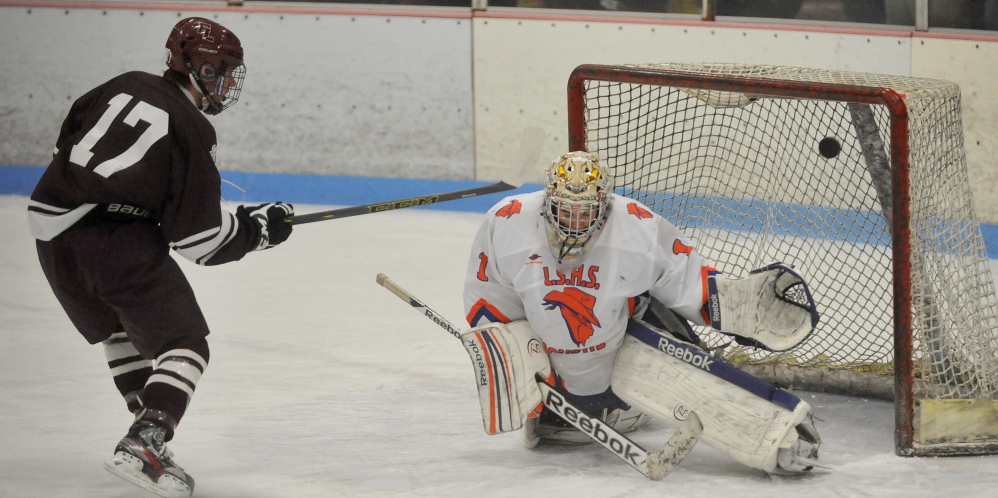 Edward Little High School’s Liam Benson (17) scores on Lawrence/Skowhegan goalie Curtis Martin during an Eastern A quarterfinal Tuesday night at Sukee Arena.