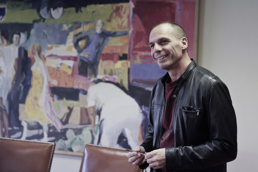 Greece’s Finance Minister Yanis Varoufakis prepares to leave his office, in central Athens, on Saturday. In an interview with the Associated Press, Varoufakis said that Greece intends to start discussions with its European partners and creditors on debt rescheduling in order to make the country’s massive debt sustainable.