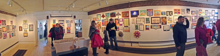 Showgoers inspect the 200 works on display at the opening of the Young at Art Show on Saturday at the Harlow Gallery in Hallowell.