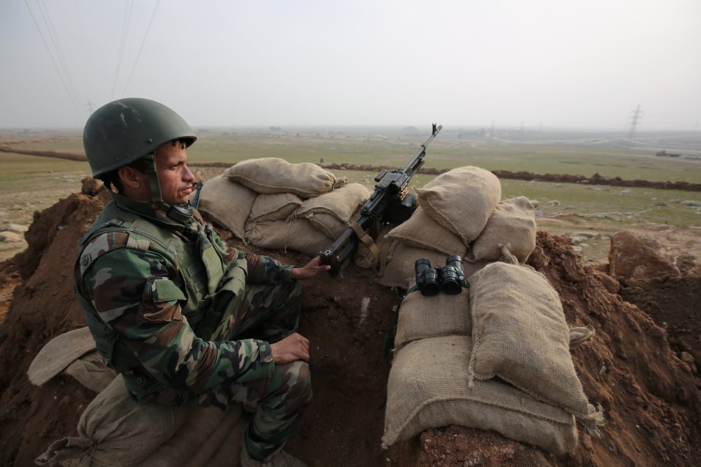 A Kurdish soldier stands guard, on the road between Mosul and Tal Afar in Iraq. Three Peshmerga brigades will be part of the effort to recapture Mosul from Islamic State militants.