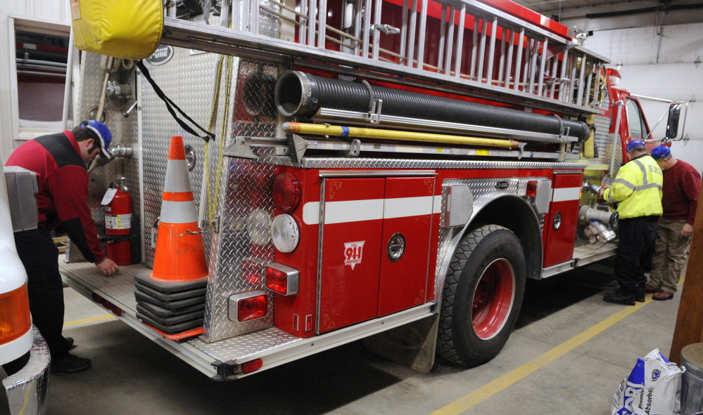 Chesterville firefighters check over equipment on one of their fire trucks recently at the fire station in Chesterville. Central Maine departments are feeling the crunch of fewer volunteers, less money and more required training.