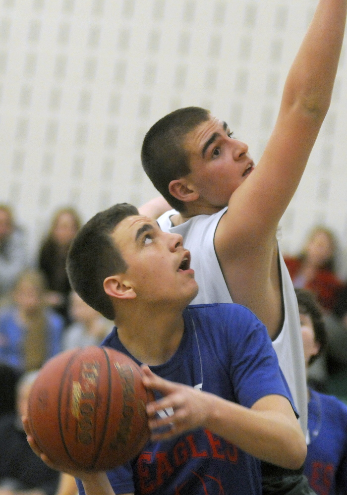 Winthrops  Dakota Brooke, right, attempts to block Messalonksee’s Tyler Elkins during a Unified quarterfinal Tuesday afternoon in Winthrop. The Ramblers prevailed 55-50.