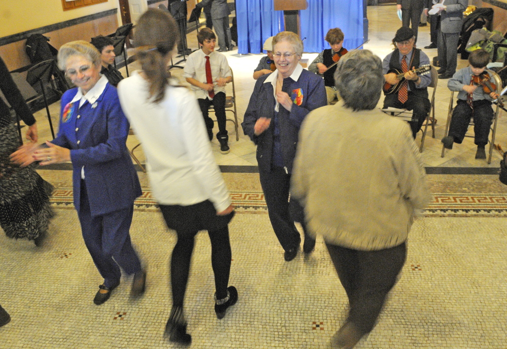 Women dance as Le Bijou Folk Orchestra performs during Franco-American Day events on Wednesday in the State House Hall of Flags. The Franco-American War Veterans Honor Guard presented the colors at the start of House and Senate sessions. Five people were also inducted into Maine’s Franco-American Hall of Fame.