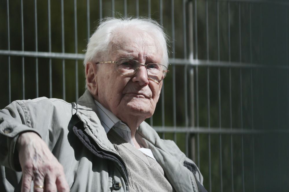 Former SS guard Oskar Groening sits in ths sun during the noon break of the trial against him in Lueneburg, northern Germany, Tuesday.