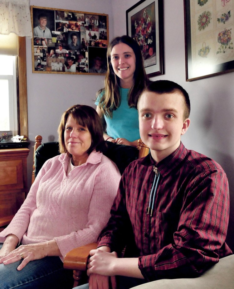 Yvonne Batson sits with her children Corina and Nathanael on Monday at their home in Fairfield. In the background are photographs of Yvonne’s son Brendan, who died in 2001. The Batsons suffer from neurofibromatosis, a genetic disorder.