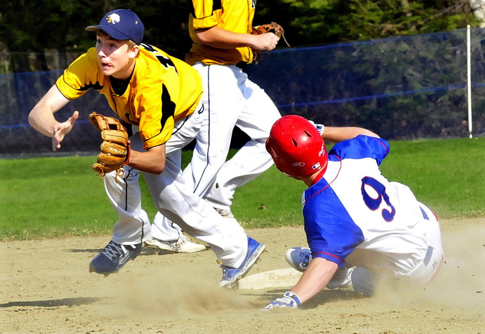 Mt. Blue’s Tom Wing awaits a throw as Messalonskee’s Zach Mathieu slides into second base safely during a Kennebec Valley Athletic Conference Class A game Monday afternoon.