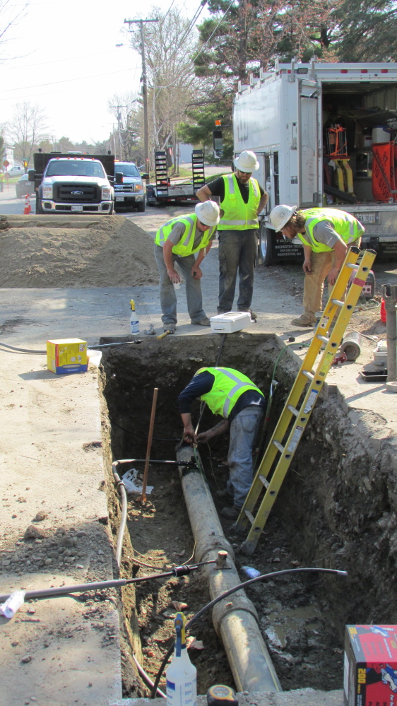 Employees from ETTI, a utilities construction company from Lisbon Falls, replace an electrofusion tee on a Summit Natural Gas line on Cool Street in Waterville Monday afternoon.