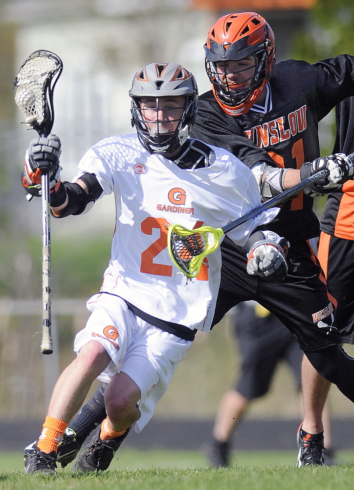 Gardiner Area High School’s Michael Glazier, left, evades Winslow High School’s Cody Olausen during a lacrosse game Wednesday in Gardiner.