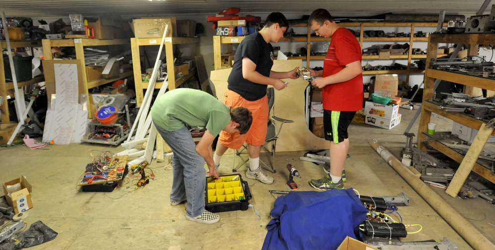 Delsin Klein, 14, center, fabricates parts for the Messalonskee robotics team robot on Thursday with teammates Geoffery Fotter, 15, left, and Ethan Pullen, 16, right, at Wrabacon in Oakland.