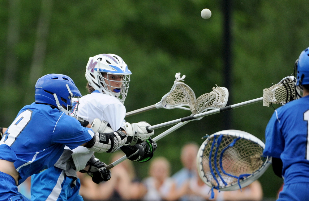 Messalonskee’s Dylan Jones, middle, tries to get a shot on goal as he is defended by Lewiston’s Ty Murphy (9) during an Eastern Class A semifinal Friday evening at Thomas College in Waterville.