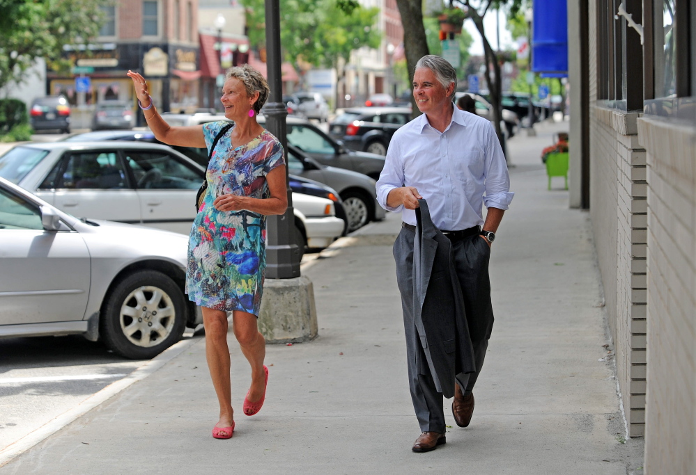 Karen Heck, former mayor of Waterville, walks with Colby College President David Greene on July 1, 2014, on Main Street in downtown Waterville.