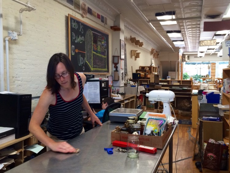 Melissa Hackett, store manager at Barrels Community Market, cleans the counters in the kitchen of the store on Monday. The store is closed for the month of August for a structural reorganization.