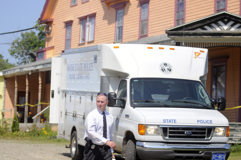 A state police detective walks Sunday out of the driveway of an East Pittston boarding home where a stabbing occurred Saturday night.