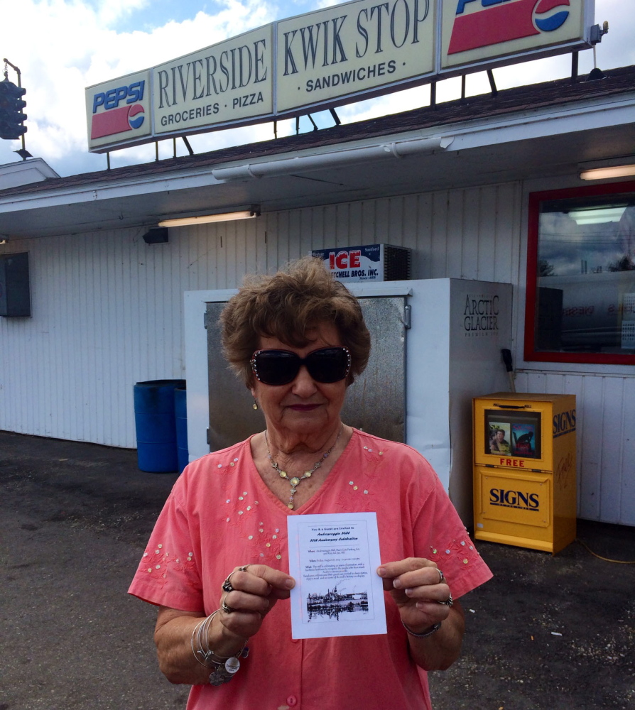 Glenda DiPompo shows a flier she got in the mail Thursday inviting her to a celebration of the mill’s 50th anniversary. DiPompo, whose husband retired from the mill and whose son works there, owns Riverside Kwik Stop and says the layoffs will hurt business.