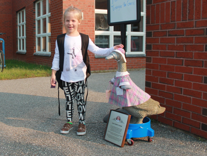 First-grader Khloie Caniff pets Georgie’s head as second-grader Abigail Rogachoff walks by with a smile.