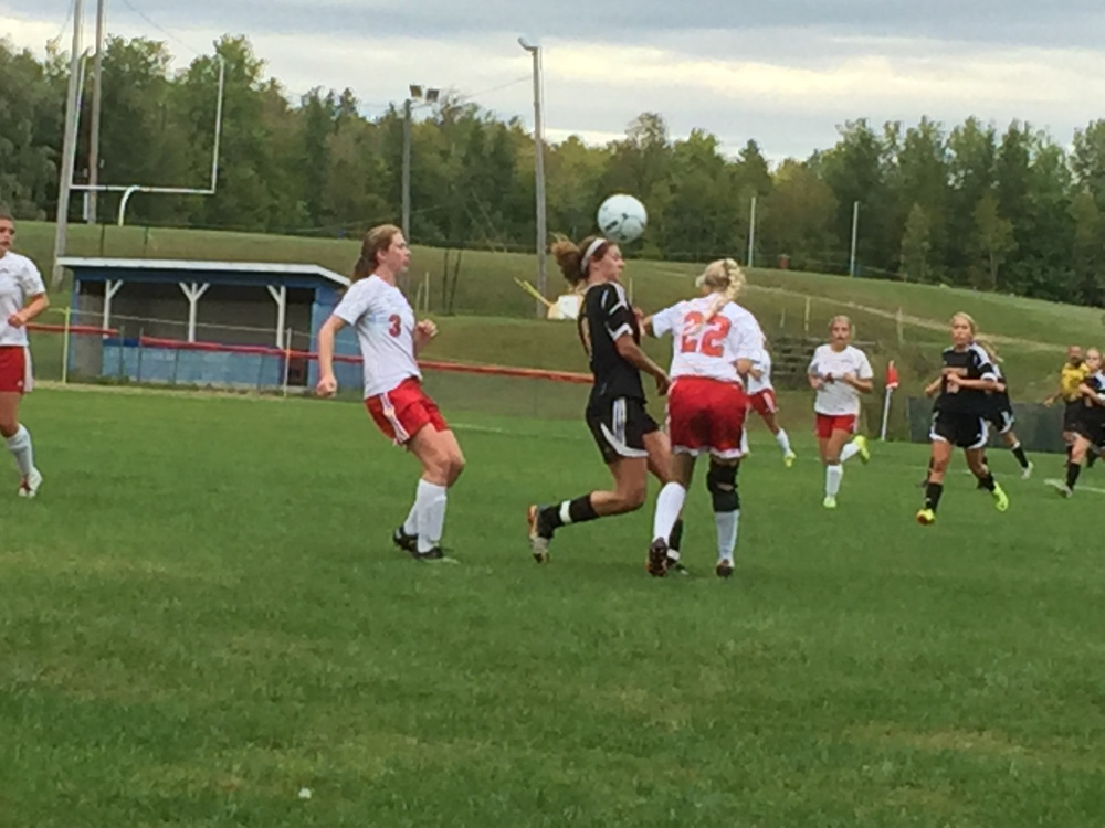 Staff photo by Randy Whitehouse 
 Messalonskee's Kathryn Mercier (22) and Ella Moore (3) close in on the ball during a game against Brewer on Friday.