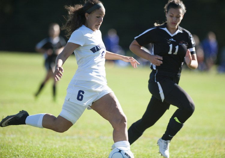 Photo by Kevin Bennett 
 Waterville's Fotini Shanos, left, takes a shot on goal while being closely defended by Winslow's Madison Morneault on Saturday at Waterville.