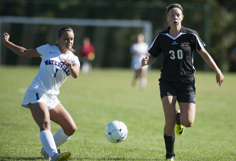 Kevin Bennett photo 
 Waterville's Mackenzie St. Pierre takes a shot on goal as Winslow's Paige Trask attempts to block the shot with her body during a Class B North game Saturday in Waterville.