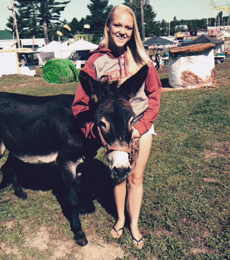 Marissa Muncey, 15, of Lincoln, stands with her donkey, Max, on Saturday at the Harmony Free Fair in Harmony. They won second place in the livestock contest.