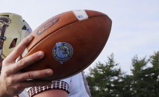 Thornton Academy quarterback Austin McCrum has the football and the joy of his teammates after scoring the fourth-quarter touchdown that put the game away.