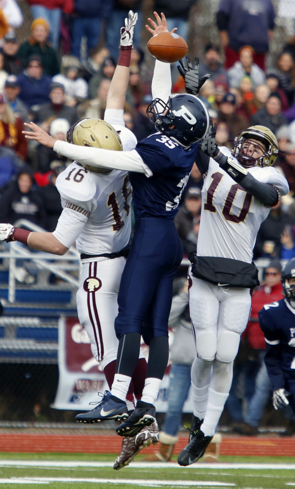 Michael Laverriere, left, and Ben Lambert of Thornton Academy combine to knock away a first-half pass intended for Dylan Bolduc of Portland. Thornton led 14-0 at halftime before Portland rallied to tie.