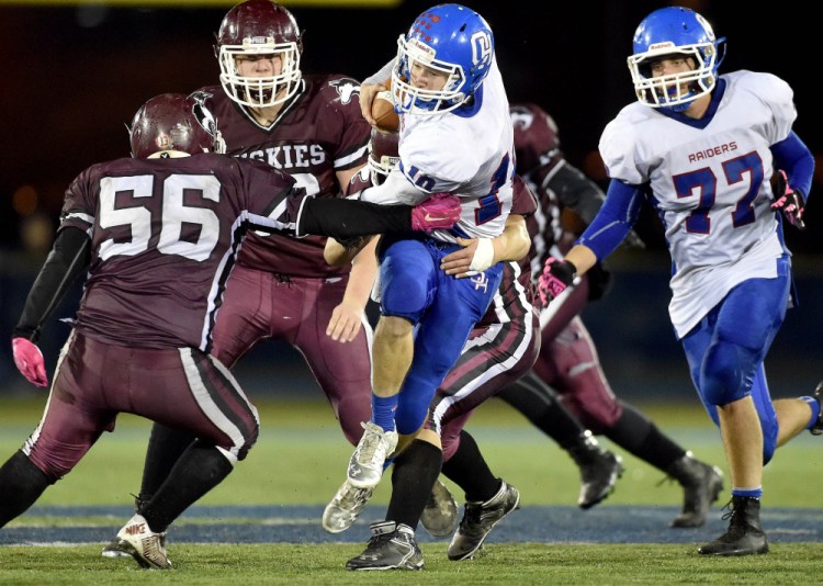 Oak Hill quarterback, Dalton Therrien (10) tries ti break though thet Maine Central Institute front during the Class D state championship game Friday night at Alfond Stadium in Orono.