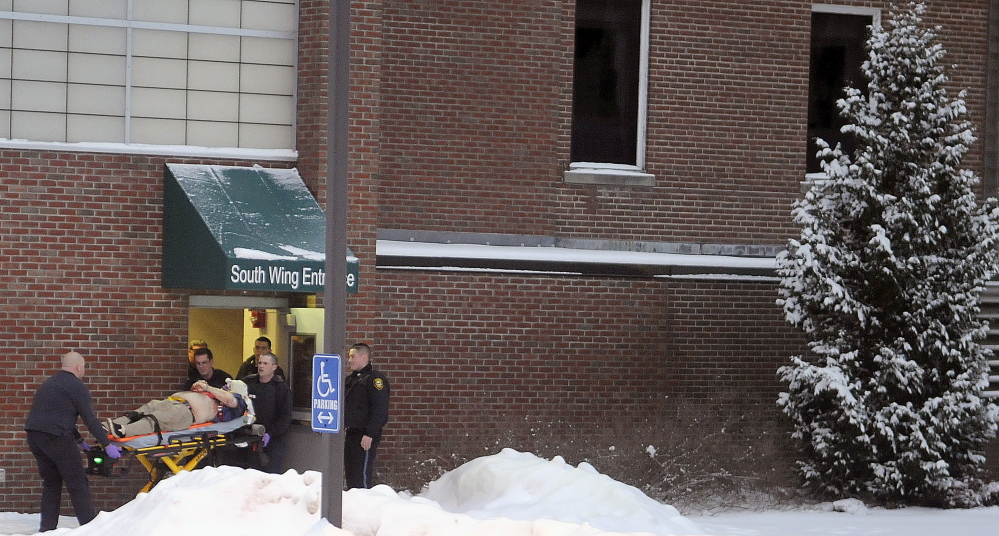 Firefighters and police escort a man, later identified as Jason Begin, who was shot by an Augusta police officer on Jan. 12 at the former MaineGeneral Medical Center in Augusta.