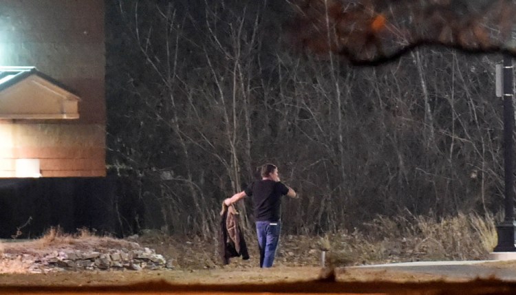 A man — later identified as Gary Cross of Troy — walks toward police with his arms extended as he surrenders after a standoff at the Waterville Police Department.