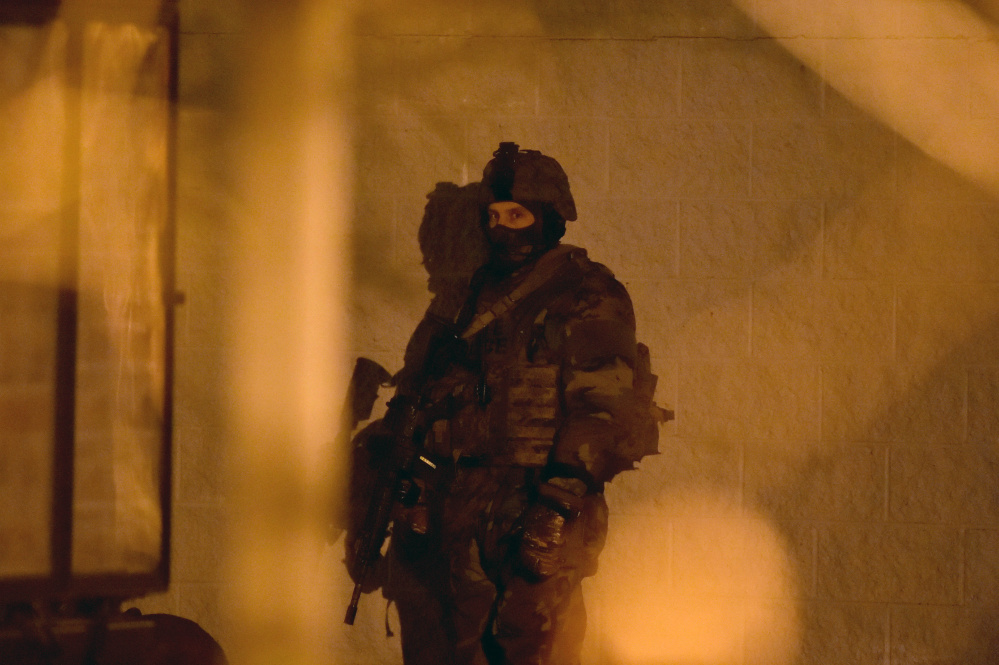 A member of the Maine State Police tactical team stands ready during a standoff at the Waterville Police Department on Tuesday.